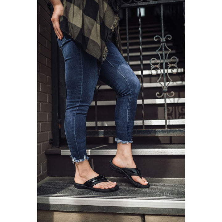 PowerStep Orthotic Arch Supporting fashion sandals for Women, woman standing on stairs in black fashion sandals with black gate in background